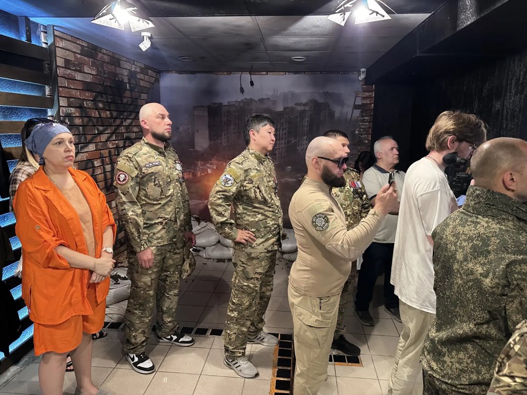 Гости музея у стенда с разрушенным городом